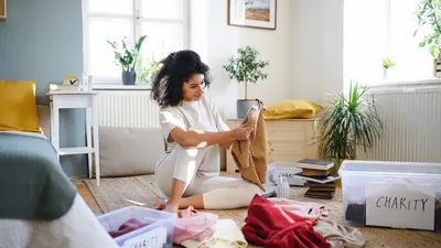 Young Woman Sorting Wardrobe Indoors At Home Charity Donation Concept.
