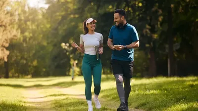 Happy Athletic Couple Communicating While Walking In Nature After Sports