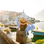 A Young Woman Traveler Enjoys The Serene Waterfront View In