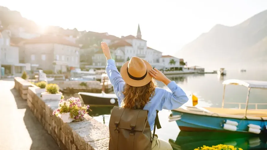 A Young Woman Traveler Enjoys The Serene Waterfront View In