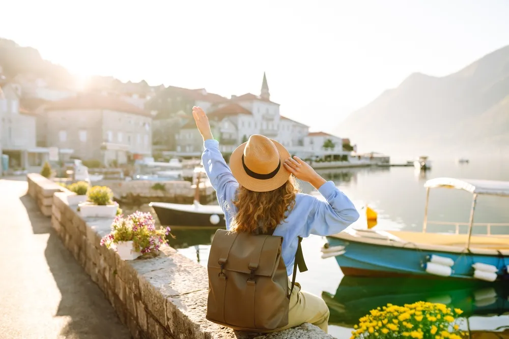A Young Woman Traveler Enjoys The Serene Waterfront View In